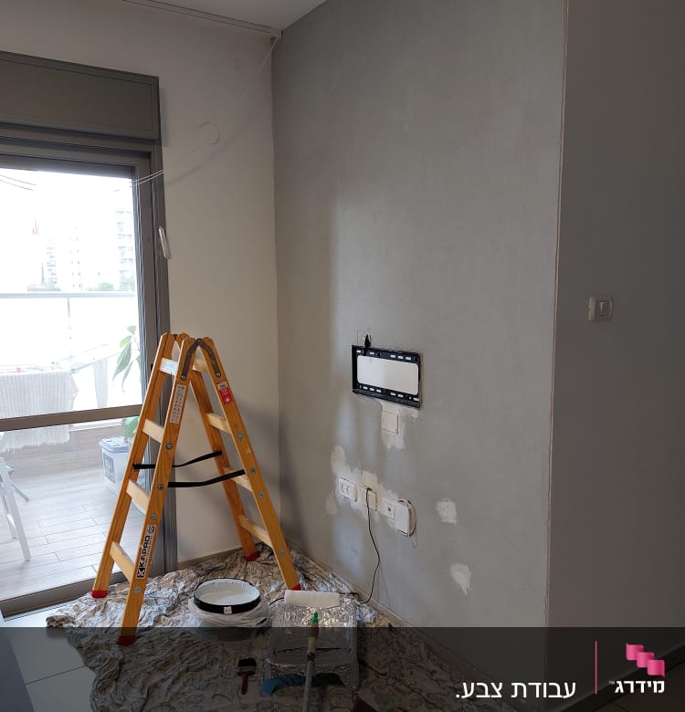 סולם, מברשת צבע, גליל צבע, קיר צבוע חלקית